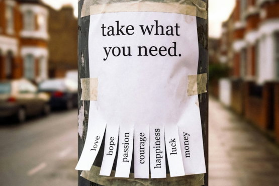 A sign on a pole reads 'take what you need.'