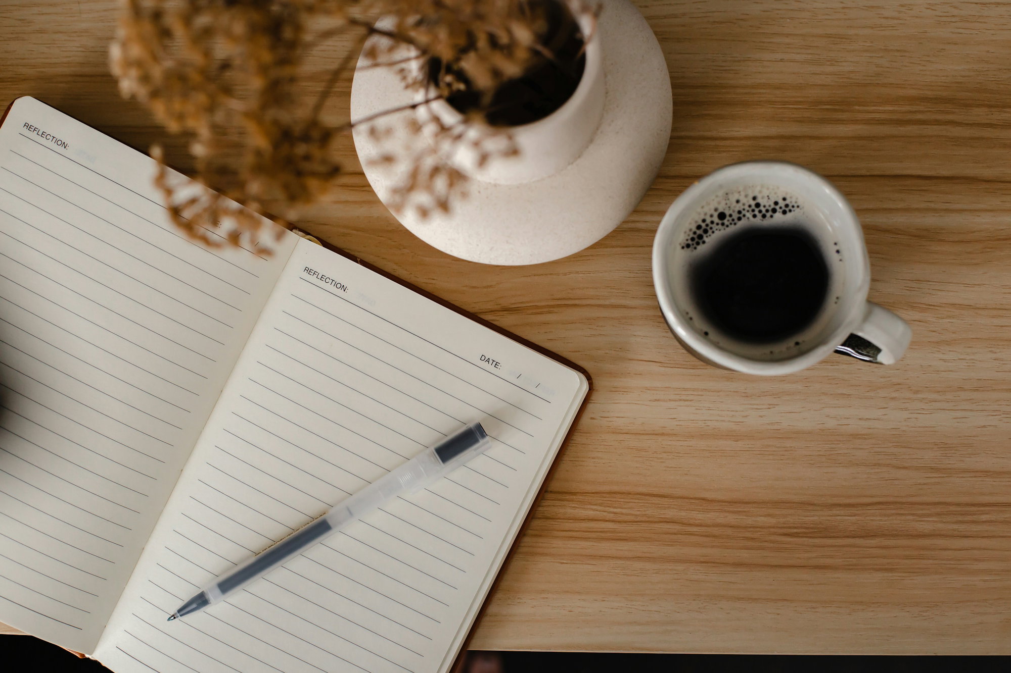 a-cup-of-coffee-and-a-notebook-on-a-table.jpg a cup of coffee and a notebook on a table
